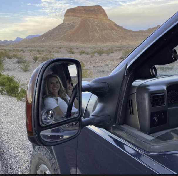 Stephanie Sutton reflected in a truck side mirror while traveling to multifamily construction sites